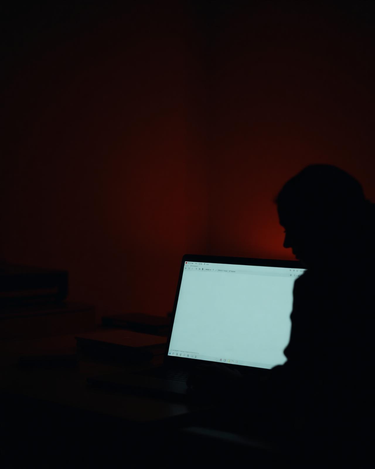 A person engaged in self-paced digital learning on a laptop in a warm workspace
